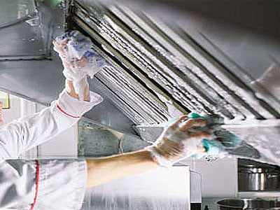 kitchen hood cleaned by two guys using sponges